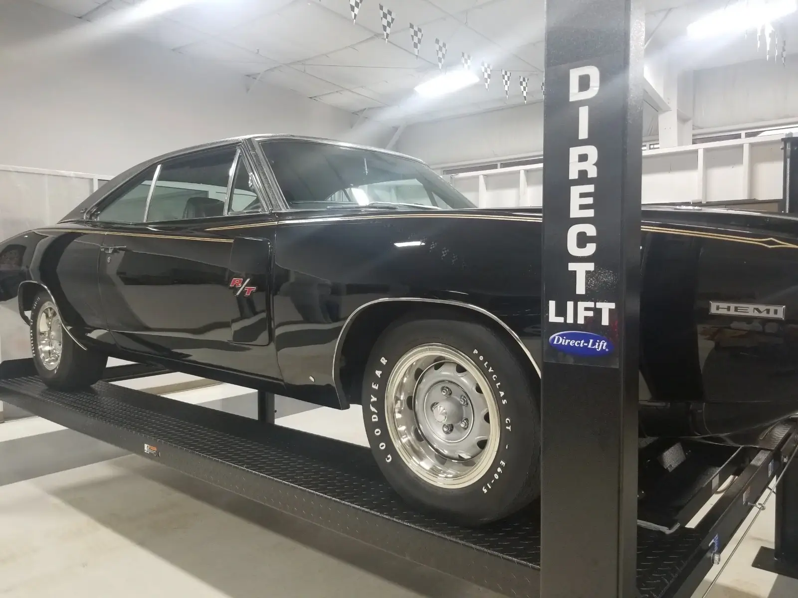 Gallery Classic black Dodge Charger R/T HEMI parked on a Direct Lift PP8S four-post car lift inside a professional garage